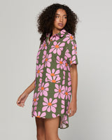 Woman wearing a floral dress with pink flowers on a green background