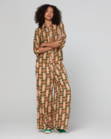 Woman wearing an orange floral shirt and matching pants