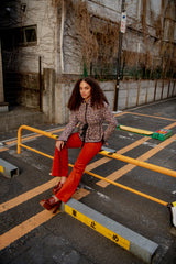Woman sitting on a concrete block in an urban setting with a yellow railing and concrete wall.