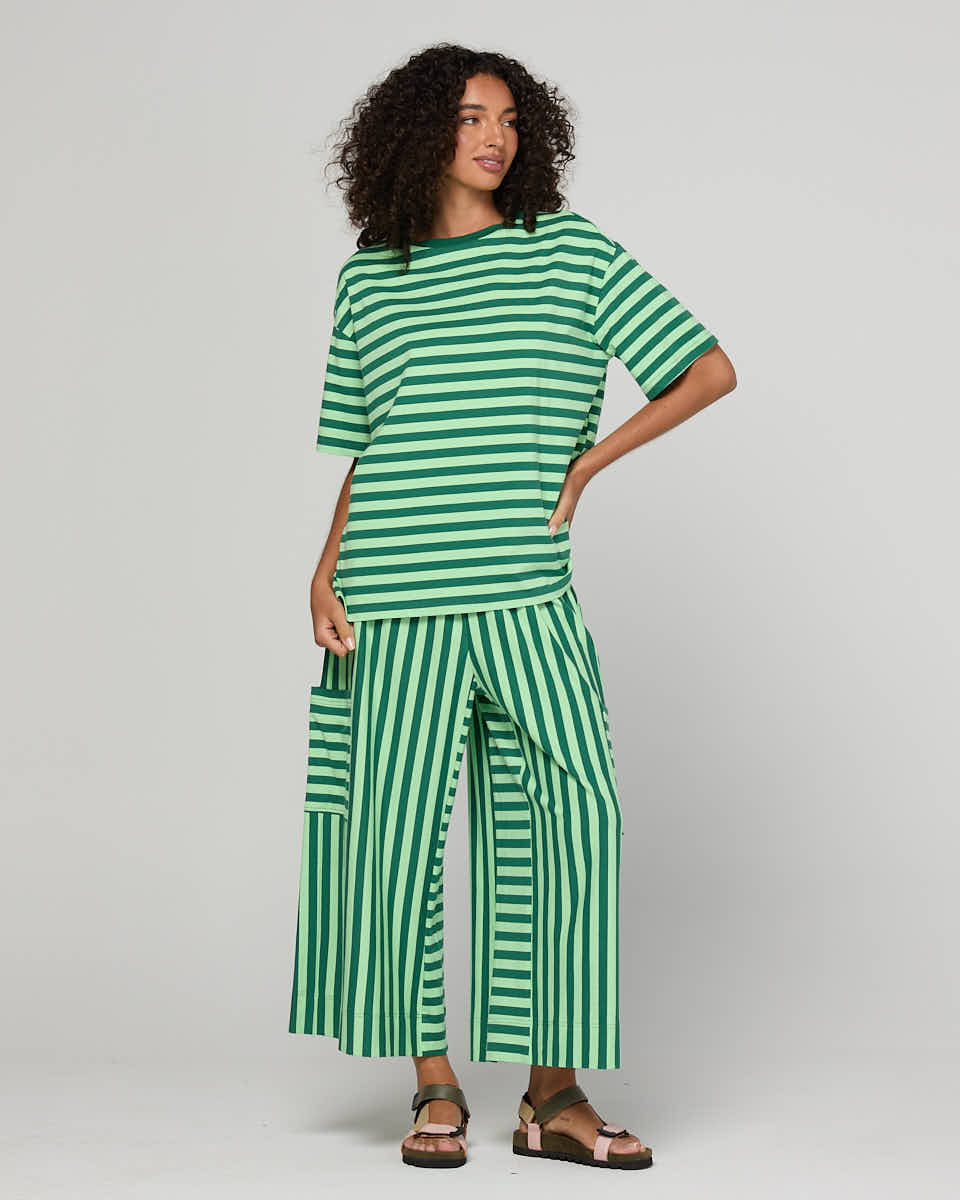 Woman wearing a green striped outfit on a gray background