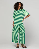 Woman wearing a green striped outfit on a gray background